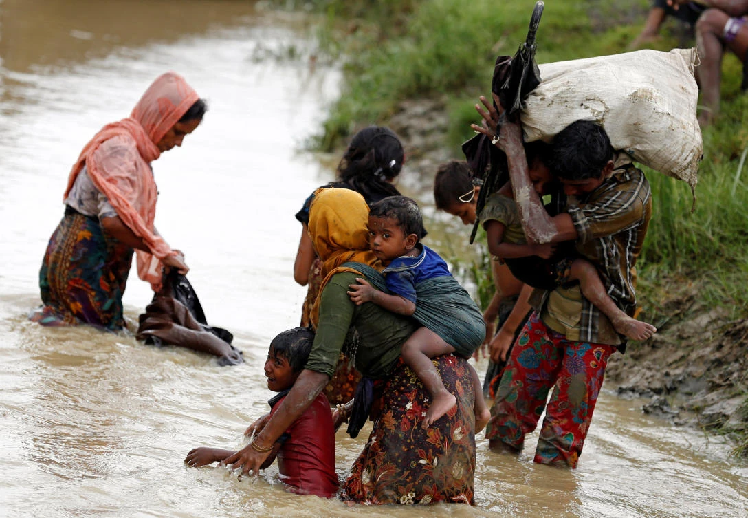 Rohingya refugees wash mud from their clothes while crossing a canal in Teknaf, Bangladesh September 1, 2017. Picture taken September 1, 2017. REUTERS/Mohammad Ponir Hossain