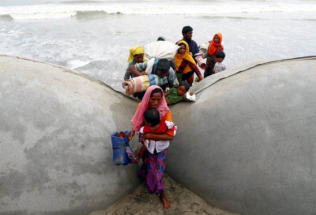 Rohingya refugees climb sand bags after crossing the Bangladesh-Myanmar border by boat through the Bay of Bengal in Teknaf, Bangladesh September 7, 2017. REUTERS/Danish Siddiqui