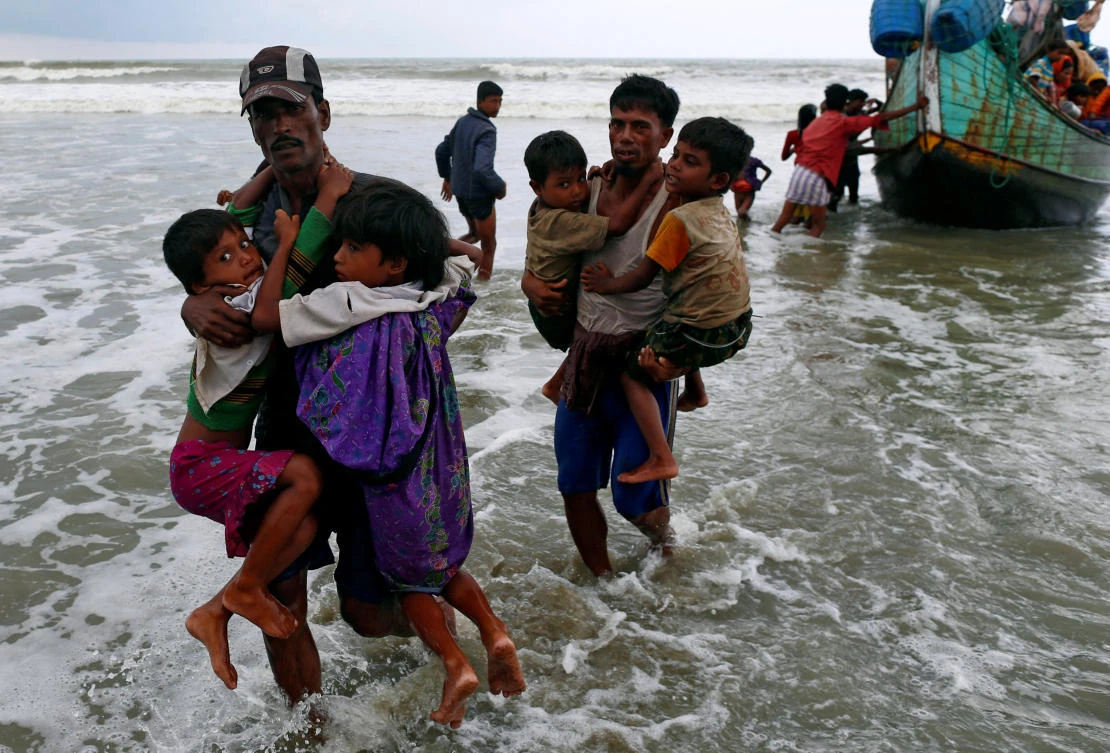 Rohingya refugee children are carried to the shore after crossing the Bangladesh-Myanmar border by boat through the Bay of Bengal in Teknaf, Bangladesh, September 7, 2017. REUTERS/Danish Siddiqui