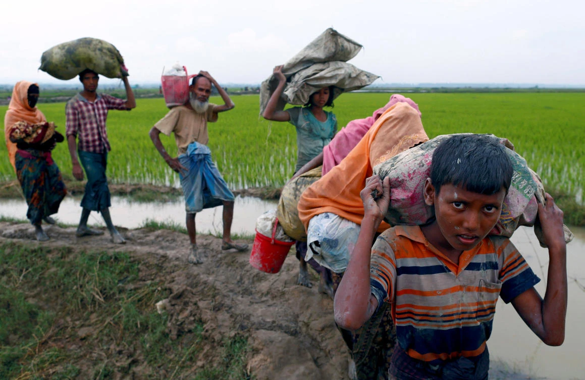 Rohingya refugees walk on a muddy path after crossing the Bangladesh-Myanmar border, in Teknaf, Bangladesh, September 6, 2017. REUTERS/Danish Siddiqui