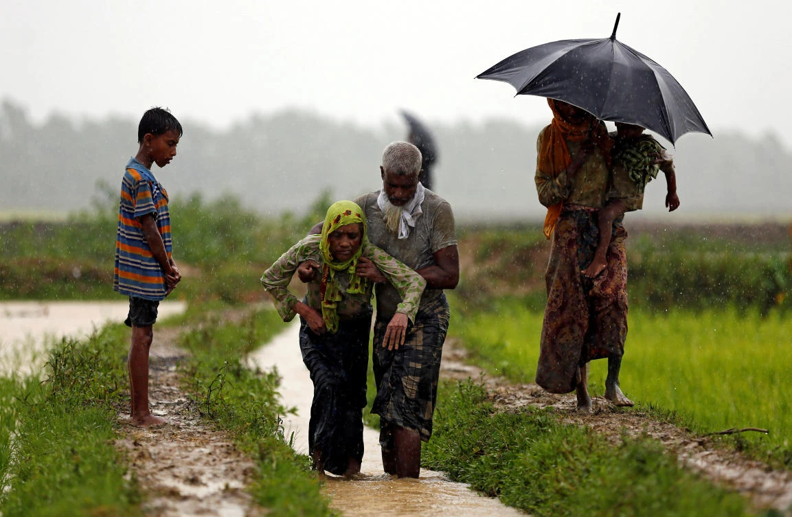 A Rohingya refugee man helps a woman to walk after crossing the border, in Teknaf, Bangladesh September 1, 2017. Picture taken on September 1, 2017. REUTERS/Mohammad Ponir Hossain