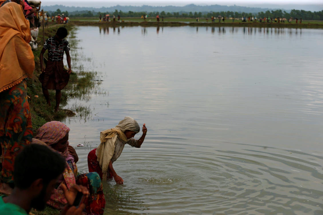 A Rohingya refugee woman splashes water on her head after crossing border in Teknaf, Bangladesh, September 7, 2017. REUTERS/Mohammad Ponir Hossain