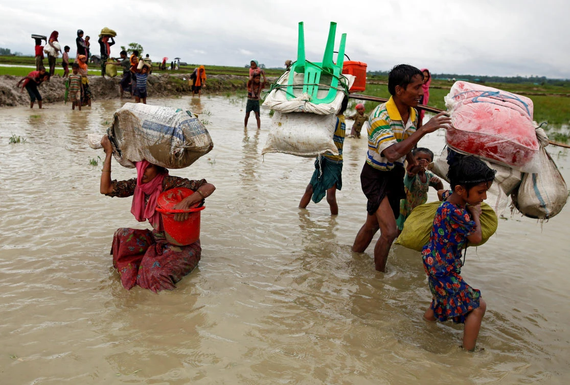 A Rohingya refugee woman falls as she walks through the water after crossing the border, in Teknaf, Bangladesh September 1, 2017. Picture taken September 1, 2017. REUTERS/Mohammad Ponir Hossain