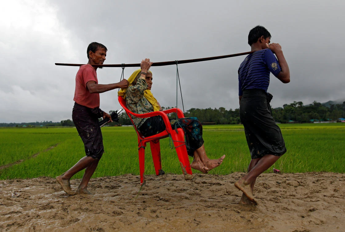 Rohingya refugee men carry an old woman as she is unable to walk after crossing the border, in Teknaf, Bangladesh September 1, 2017. Picture taken September 1, 2017. REUTERS/Mohammad Ponir Hossain