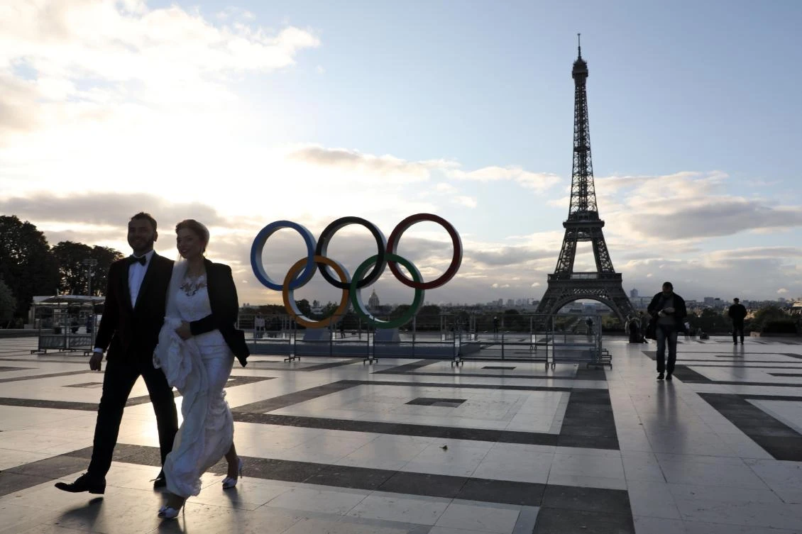 A married couple walks on the Esplanade du Trocadero where Olympic rings have been installed following the city's nomination as host for the 2024 Olympics, on September 14, 2017 near the Eiffel tower in Paris. / AFP / LUDOVIC MARIN