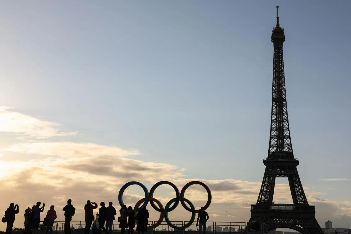 People take photos of the Olympic rings installed on the Esplanade du Trocadero near the Eiffel tower following the Paris' nomination as host for the 2024 Olympics, on September 14, 2017 in Paris. / AFP / LUDOVIC MARIN