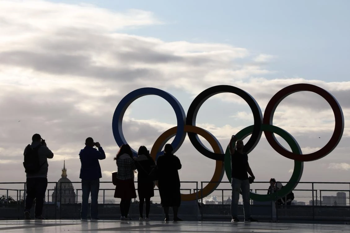 People take pictures of the Olympic rings installed on the Esplanade du Trocadero following the Paris' nomination as host for the 2024 Olympics, on September 14, 2017 in Paris. / AFP / LUDOVIC MARIN