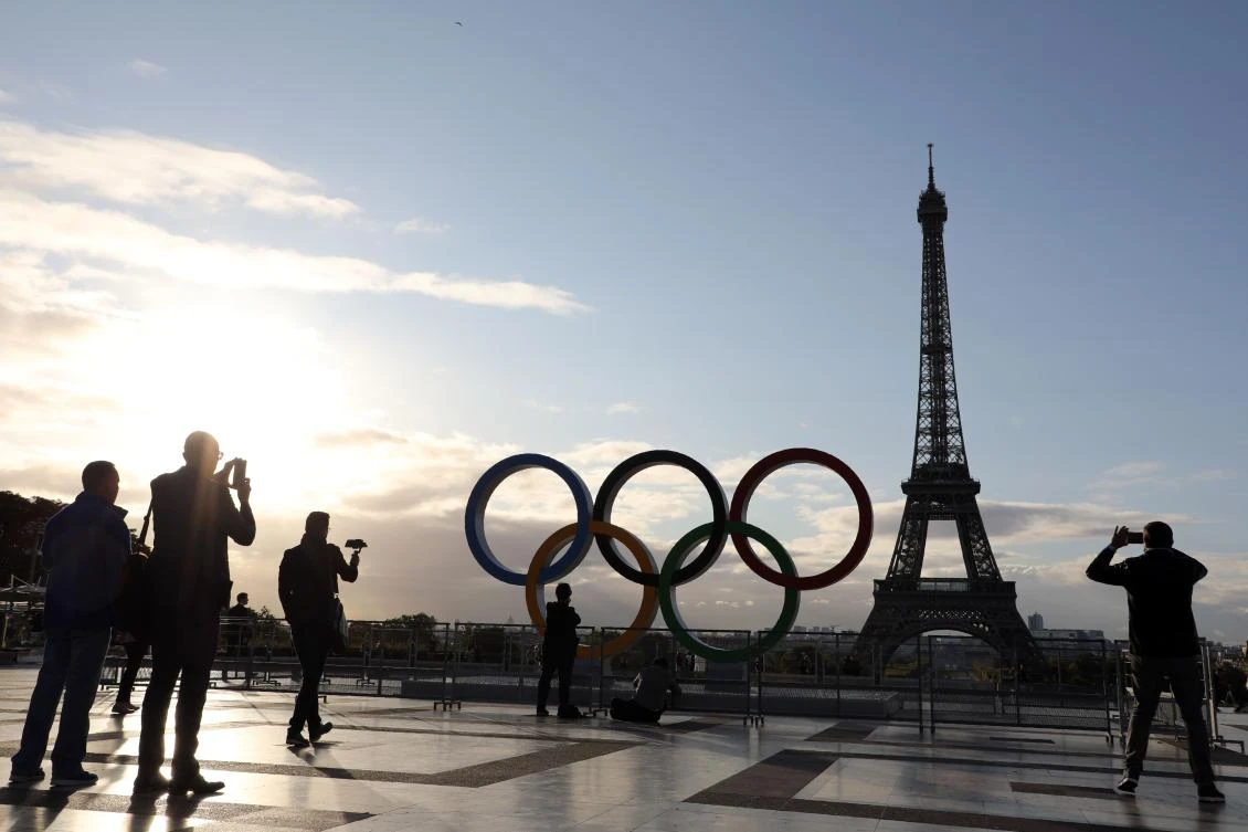 People take pictures of the Olympic rings installed on the Esplanade du Trocadero near the Eiffel tower following the Paris' nomination as host for the 2024 Olympics, on September 14, 2017 in Paris. / AFP / LUDOVIC MARIN