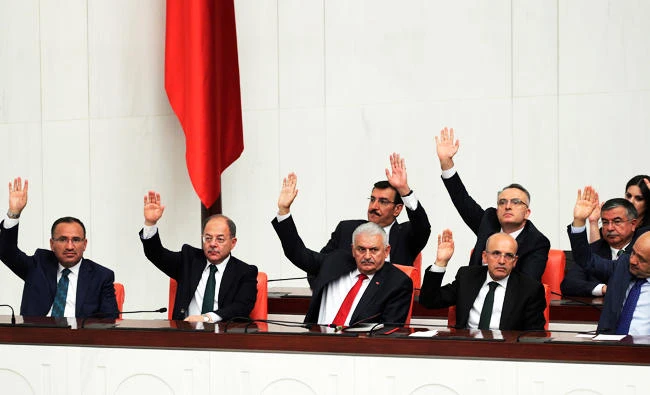 Turkey's Prime Minister Binali Yildirim, front- center, and his deputies vote to extend a new mandate at the parliament during an extraordinary session, in Ankara, Turkey, on Saturday. (AP)