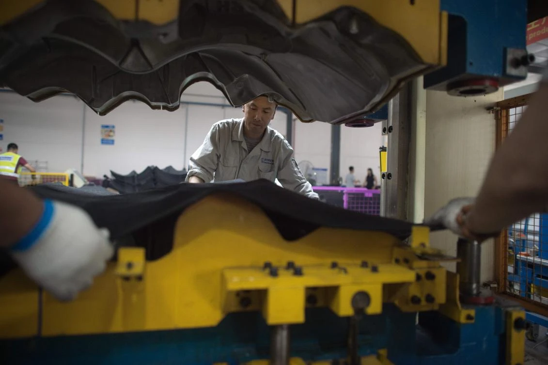 The EU business chamber has observed an uptick in foreign entrepreneurs arriving in Shenyang in recent years. Above, workers manipulate a machine to produce car interior pieces for a major European carmaker. (AFP)
