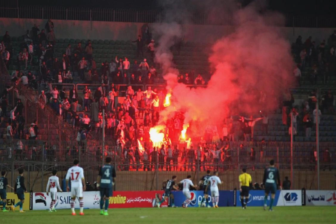 Soccer fans hold lit flares at the stand as they watch a match between Egyptian Premier League clubs Zamalek and ENPPI at Air Defense Stadium in a suburb east of Cairo, Egypt, on Sunday, February 8, 2015. (File photo by AP)