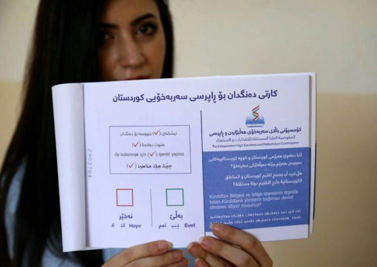 Yes or no: an employee with the Kurdish electoral commission in Arbil shows a ballot book for Monday's vote. (AFP)
