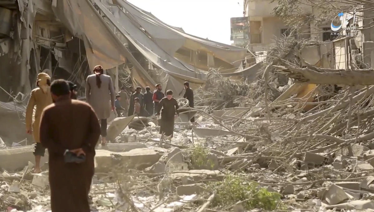 People inspecting damage from airstrikes and artillery shelling in the northern city of Raqqa, Syria in this undated frame grab from a video posted online by the Aamaq News Agency, a media arm of the Daesh group, on Monday, May 29, 2017. (File photo: Aamaq News Agency via AP)