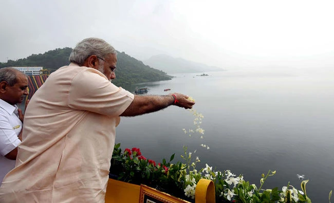 Indian Prime Minister Narendra Modi makes an offering as he visits the Sardar Sarovar Dam in Narmada in the state of Gujarat on September 17, 2017. Modi on Monday launched a $2.5 billion project to electrify all of the country’s households by the end of 2018. (Indian Press Information Bureau via AFP)