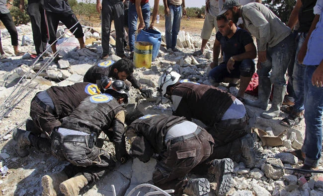 This photo provided by the Syrian Civil Defense White Helmets, which has been authenticated based on its contents and other AP reporting, shows civil defense workers searching in the rubble after airstrikes hit in Khan Sheikhoun, in the northern province of Idlib, Syria, on Sept, 24, 2017. (Syrian Civil Defense White Helmets via AP)