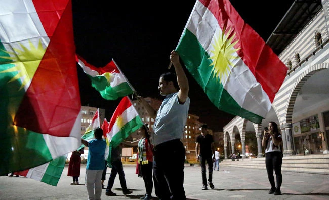 People wave Kurdish flags in Diyarbakir, Turkey on Monday. (Reuters)