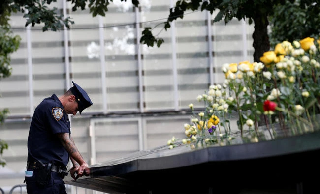 A New York City Police Department (NYPD) officer pauses at the edge of the south reflecting pool at the National 9/11 Memorial and Museum during ceremonies marking the 16th anniversary of the attacks in New York on September 11, 2017. (REUTERS/Brendan McDermid)