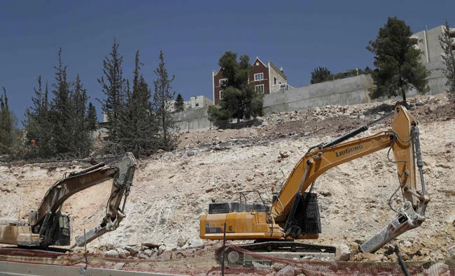 Diggers are seen on action in Ramat Shlomo, a Jewish settlement in the mainly Arab eastern sector of Jerusalem, on September 13, 2017. Israeli settlements are seen as illegal under international law and major stumbling blocks to peace as they are built on land the Palestinians see as part of their future state. (AFP / AHMAD GHARABLI)