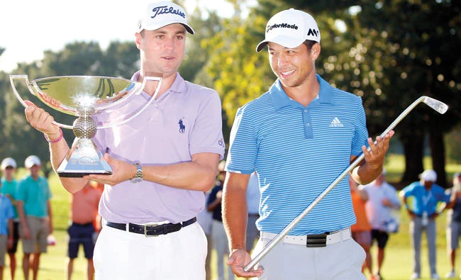 Justin Thomas hoists the trophy after winning the FedEx Cup with Xander Schauffele holding Calamity Jane, a replica of Bobby Jones putter, after winning the Tour Championship golf tournament at East Lake Golf Club on Sunday. (USA TODAY Sports)