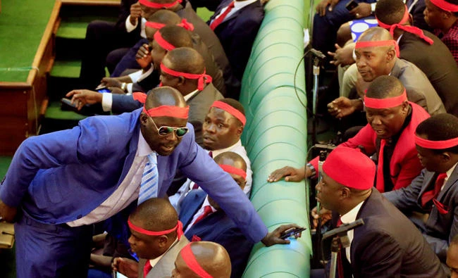 Ugandan opposition lawmakers wear red ribbon to protest in the parliament a proposed age limit amendment bill debate a move to change the constitution to extend the president's rule in Kampala, Uganda, on Tuesday, September 26, 2017. (REUTERS/James Akena)