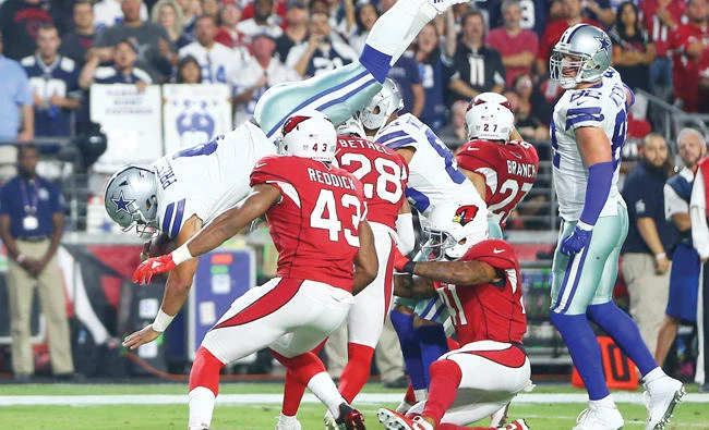 Dallas Cowboys quarterback Dak Prescott leaps over Arizona Cardinals defenders to score a touchdown in the second quarter at University of Phoenix Stadium on Monday. (USA TODAY Sports)
