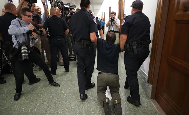 US Capitol Police arrest protesters who shouted and interrupted a Senate Finance Committee hearing about the proposed Graham-Cassidy Healthcare Bill in the Dirksen Senate Office Building on Capitol Hill on September 25, 2017 in Washington, DC. (Chip Somodevilla/Getty Images/AFP)