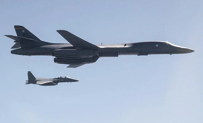 This US Air Force handout photo obtained September 24, 2017 shows A US Air Force B-1B Lancer, flanked by Republic of Korea Air Force F-15K Slam Eagles, dropping a 2,000 pound live munition at Pilsung Training Range, South Korea, in this September 18, 2017 photo, as a part of a show of force mission in response to unlawful North Korean ballistic missile tests. (AFP)