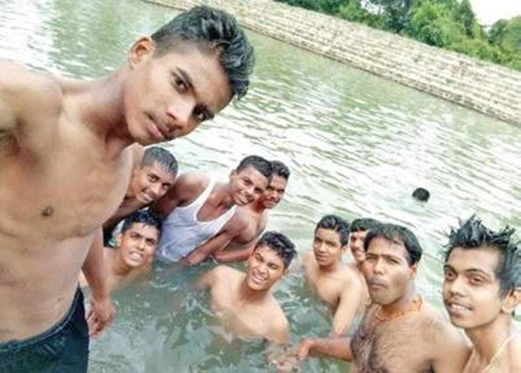 Students pose for a selfie, unaware that in the background their friend is drowning