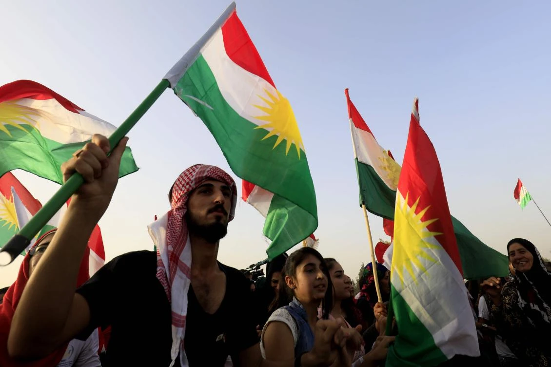 Syrian Kurds wave the Kurdish flag, in the northeastern Syrian city of Qamishli on September 26, 2017. (File photo by AFP)
