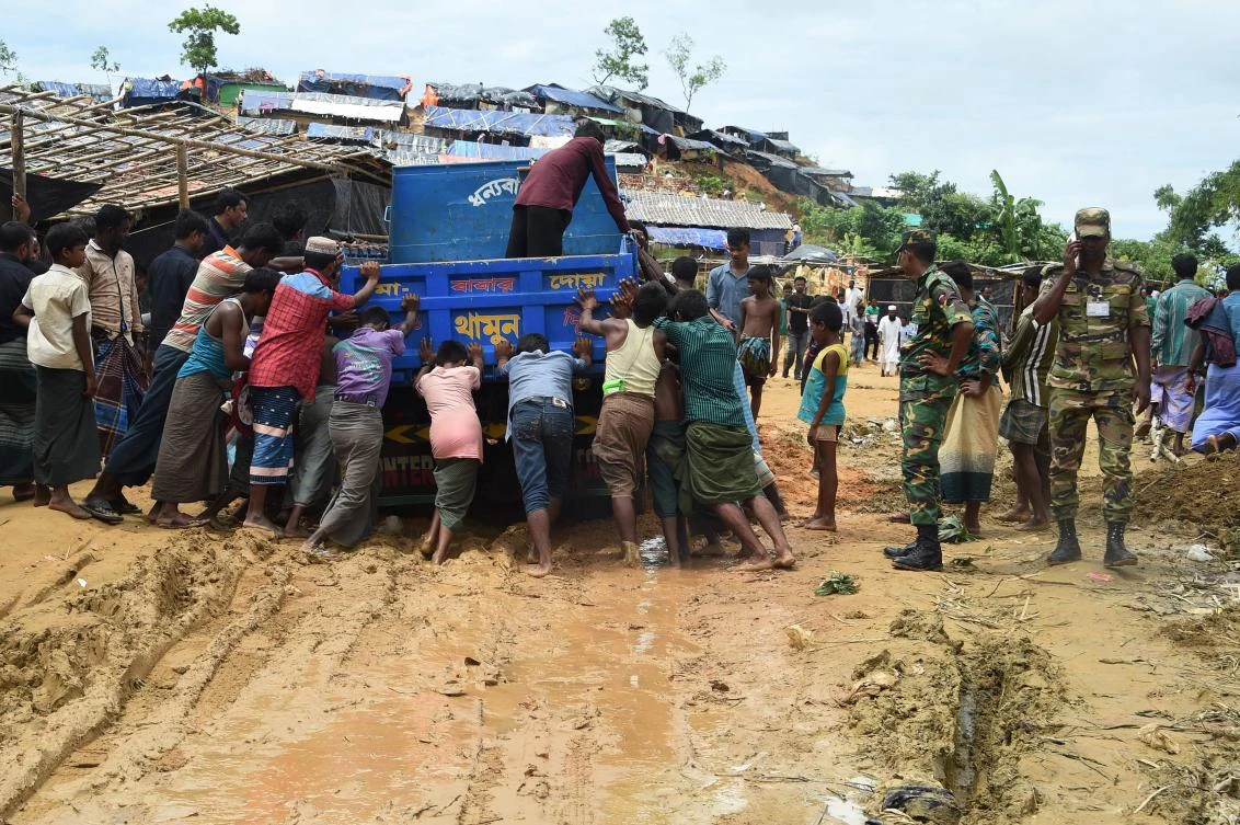 Rohingya refugees push a truck at the Thangkhali refugee camp near Ukhia on September 27, 2017. (AFP)