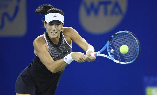 Garbine Muguruza of Spain hits a return against Magda Linette of Poland during their third round women's singles match at the WTA Wuhan Open tennis tournament in Wuhan, in China's central Hubei province, on Wednesday. (AFP)