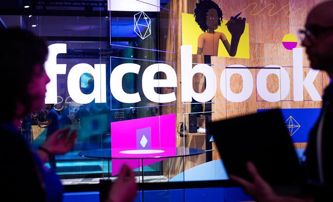 In this April 18, 2017, file photo, conference workers speak in front of a demo booth at Facebook's annual F8 developer conference, in San Jose, Calif. (AP)