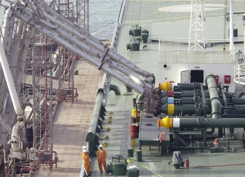 Workers oversee the loading of crude oil into a Kazimah III oil tanker at Ahmadi North Pier in Kuwait on April 3, 2006. (Reuters)