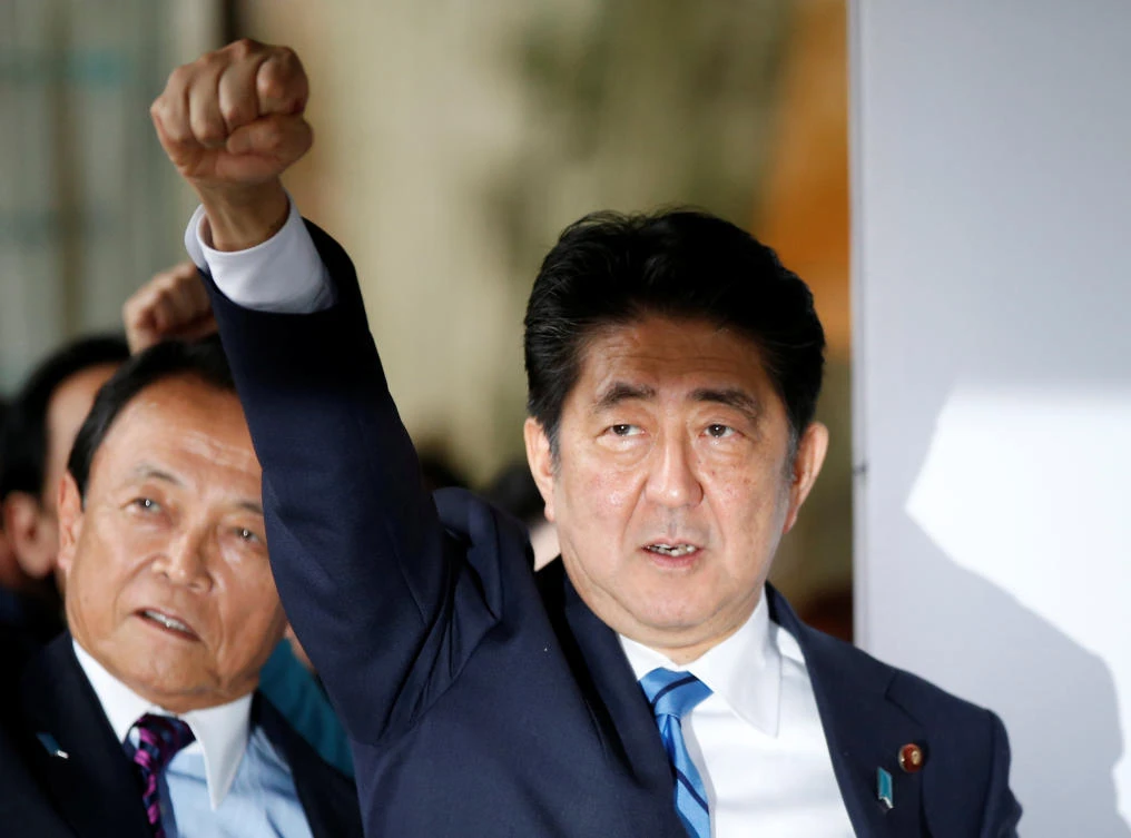 Japan’s Prime Minister Shinzo Abe and his party’s lawmakers raise their fists as they pledge to win in the upcoming lower house election in Tokyo