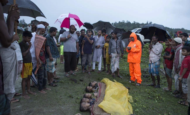 People gathered around the bodies of Rohingya Muslim refugee children, lined up near the shore of Inani beach, near Cox’s Bazar after their boat capsized. (AFP)