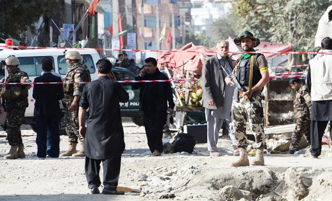 Afghan policemen stand guard at the site of a suicide bomb attack near a Shiite mosque in Kabul on Friday. (AFP)