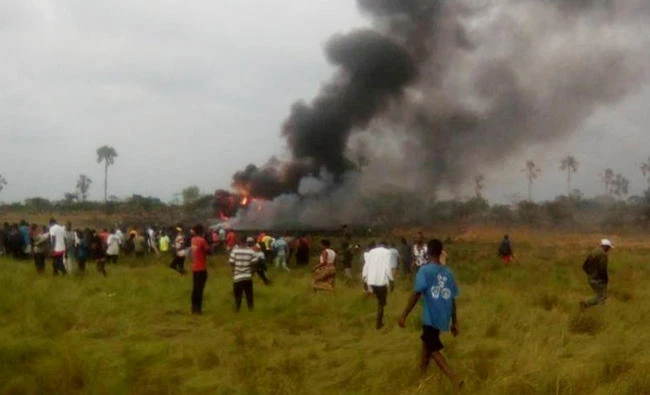 A photograph taken with a mobile phone shows civilians gathering near the burning wreckage of a military cargo plane that crashed in Kinshasa, Democratic Republic of Congo on Saturday. (Reuters)