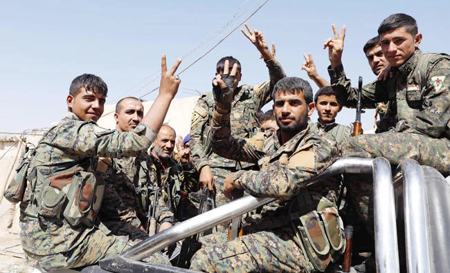 Fighters of the Syrian Democratic Forces gesture a victory sign as they ride a truck on the way to the frontline in Raqqa on Sunday. (Reuters)