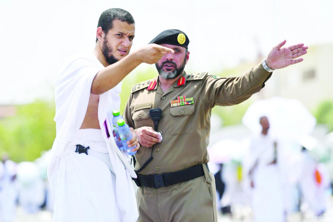 A pilgrim gets directions from a security officer in Mina. (SPA)