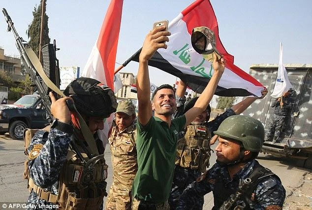 Joyous members of the Iraqi federal police celebrated in the Old City of Mosul after the country's government announced victory against the terrorists in Mosul. (AFP)