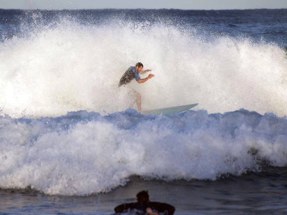 A file photo shows a surfer riding a wave at Freshwater Beach in Sydney on July 20, 2017. Australia recorded its highest daytime winter temperatures on record this year amid a long-term warming trend largely attributed to climate change, the weather bureau said on September 1, 2017. (AFP)