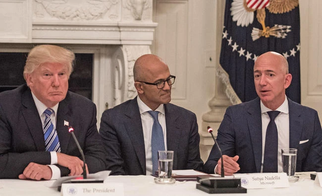 US President Donald Trump (left) and Microsoft CEO Satya Nadella (center) listen to Amazon CEO Jeff Bezos during an American Technology Council roundtable at the White House in Washington, DC. (AFP)