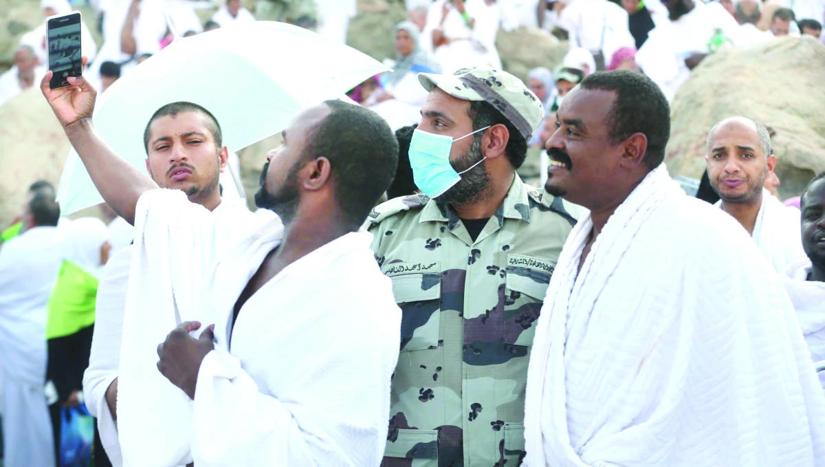 Hajj pilgrims take a selfie with Saudi security official in Mina on Friday. (AN photo by Saad Enezi)