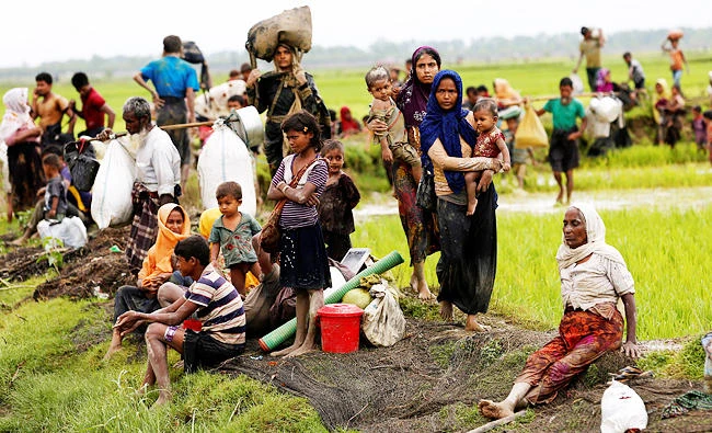 Rohingya refugees rest after travelling over the Bangladesh-Myanmar border in Teknaf, Bangladesh, on Friday. (REUTERS)