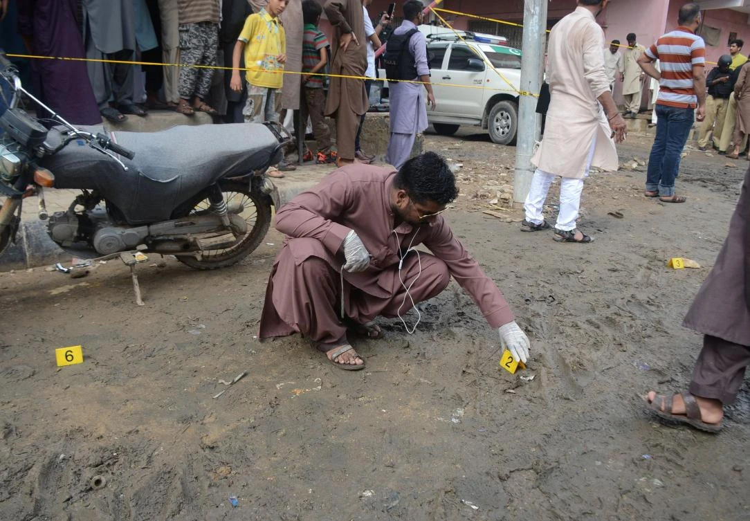 A Pakistani investigator inspects the site of an attack on an opposition politician in Karachi, on September 2, 2017. (AFP)