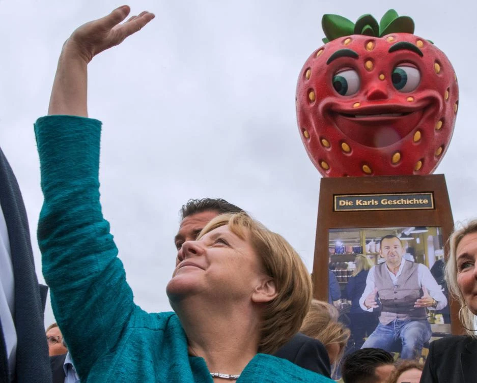 German Chancellor Angela Merkel waves to supporters as she visits a strawberry farm during an election campaign event on August 31, 2017 in Roevershagen near Rostock, northeastern Germany. (AFP)