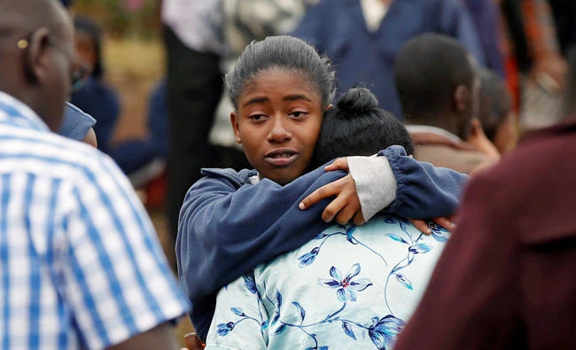A student embraces her parent following a fire which burned down one dormitory of Moi Girls school in Nairobi, Kenya on Saturday. (Reuters)