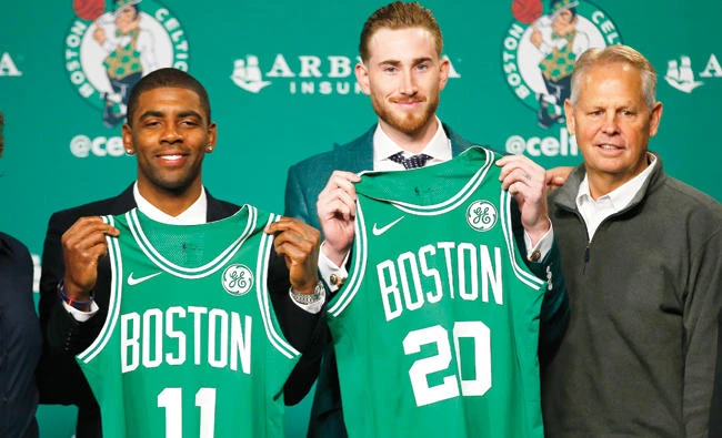 Boston Celtics' Kyrie Irving, left, and Gordon Hayward hold up their new jerseys with General Manager Danny Ainge, right, during a news conference in Boston Friday. (AP)