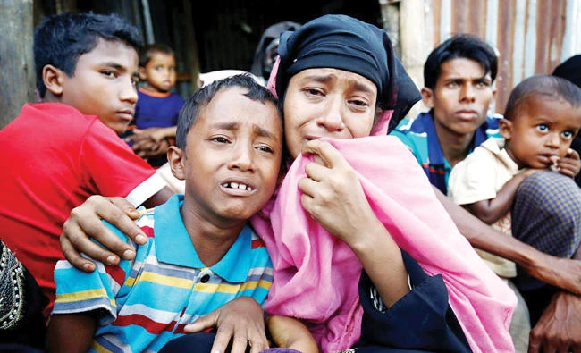 A Rohingya Muslim woman and her son cry after being caught by Border Guards Bangladesh while illegally crossing at a check point in Cox’s Bazar. (Reuters)