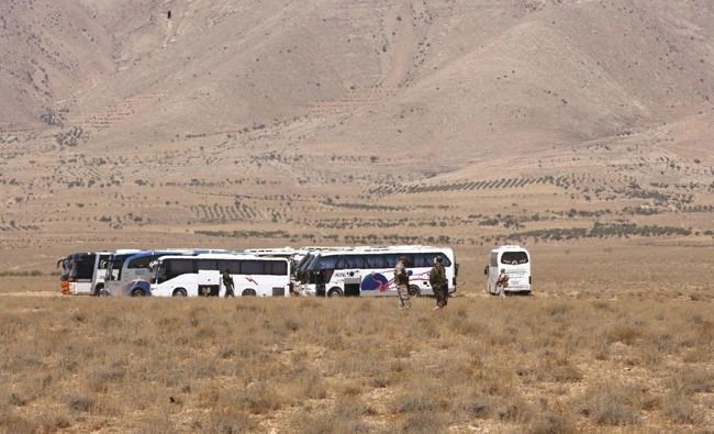 Vehicles waiting to transport Daesh members are seen in the Qara area in Syria’s Qalamoun region on August 28, 2017 as part of a deal between Hezbollah and Daesh fighters where the jihadists would leave to eastern Syria. (AFP / Louai Beshara)